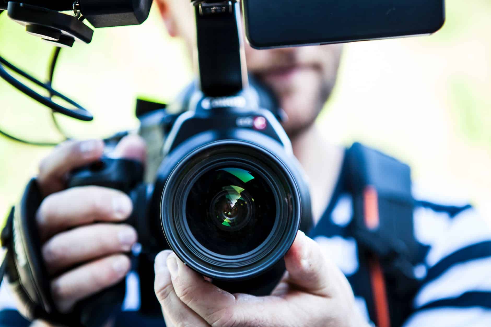 Cameraman with camera including rig. Background out of focus.